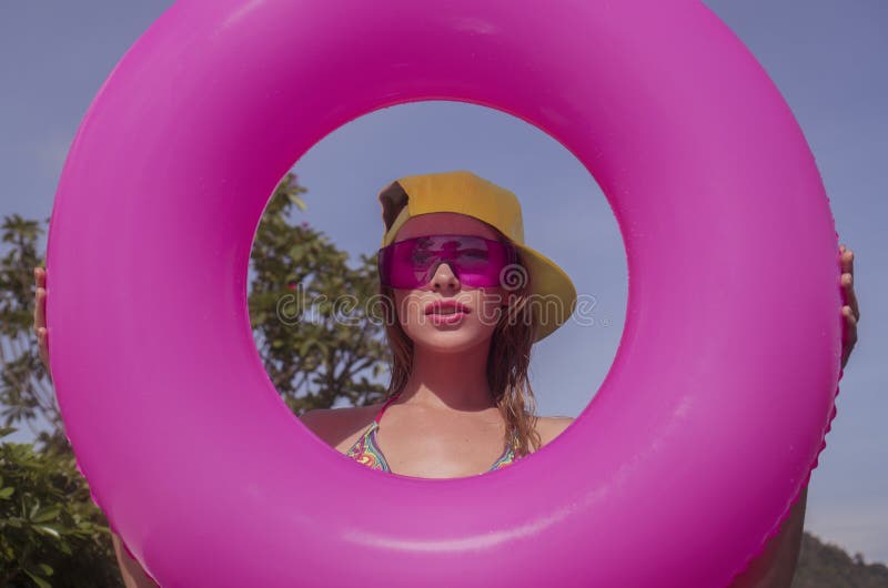 Mulher consideravelmente nova do bikni no meio do anel inflável cor-de-rosa fotos de stock Mulher consideravelmente nova do bikni no meio do anel inflável cor-de-rosa fotos de stock