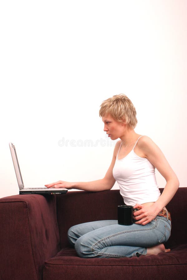 Adult beauty white woman sitting on the sofa with laptop and cup of tea. Adult beauty white woman sitting on the sofa with laptop and cup of tea