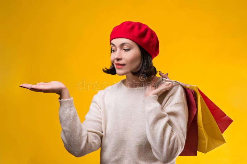 Mulher da compra que mostra algo com a palma aberta da mão Menina feliz que guardara sacos de compras Cliente da mulher da forma imagens de stock royalty free Mulher da compra que mostra algo com a palma aberta da mão Menina feliz que guardara sacos de compras Cliente da mulher da forma imagens de stock royalty free