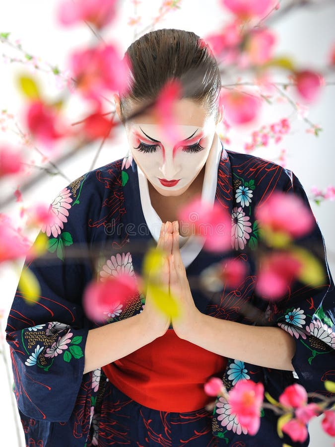 Artistic portrait of japan geisha woman with creative make-up near sakura tree. Artistic portrait of japan geisha woman with creative make-up near sakura tree