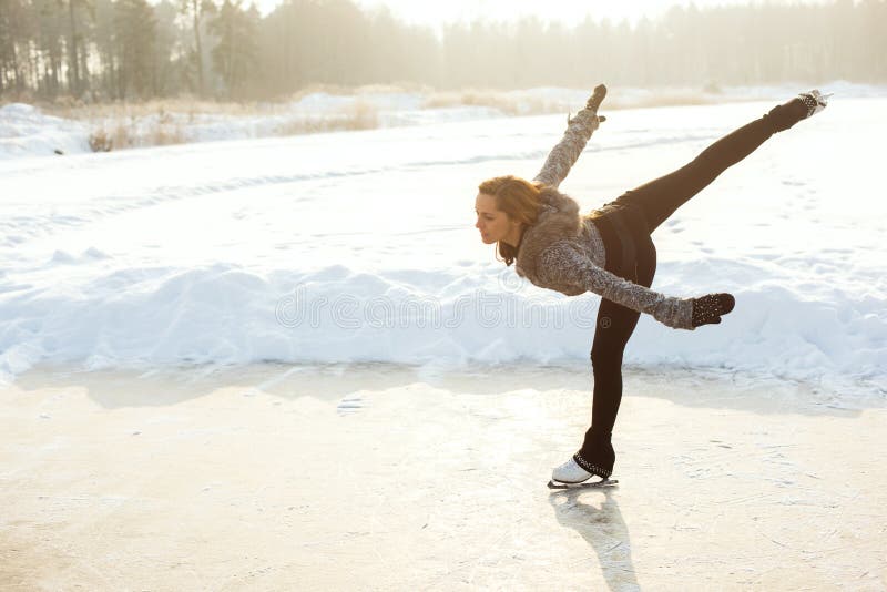 Mulher da patinagem artística no lago congelado