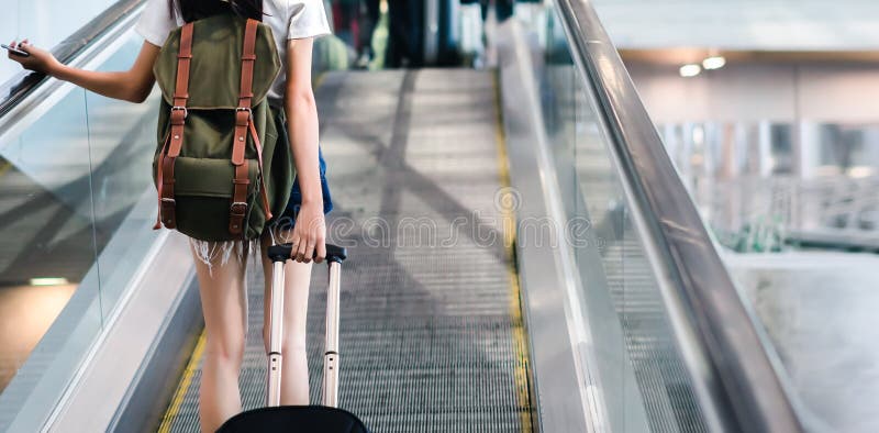 Mulher da seção mestra com a bagagem que viaja no aeroporto