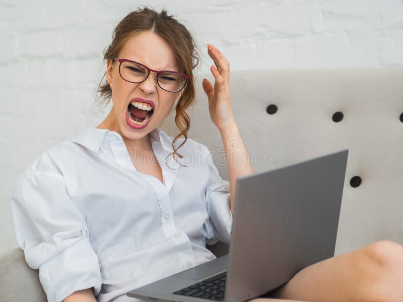 A mulher de carreira agressiva trabalha em casa Mulher gritando e frustrante com portátil fotografia de stock A mulher de carreira agressiva trabalha em casa Mulher gritando e frustrante com portátil fotografia de stock