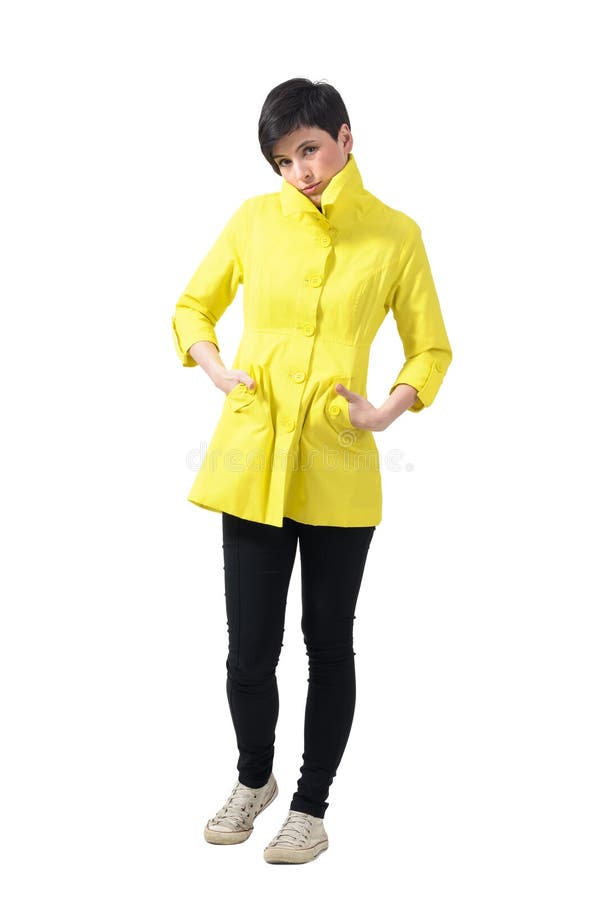 Mulher de congelação triste na capa de chuva amarela com mãos em uns bolsos fotografia de stock royalty free Mulher de congelação triste na capa de chuva amarela com mãos em uns bolsos fotografia de stock royalty free