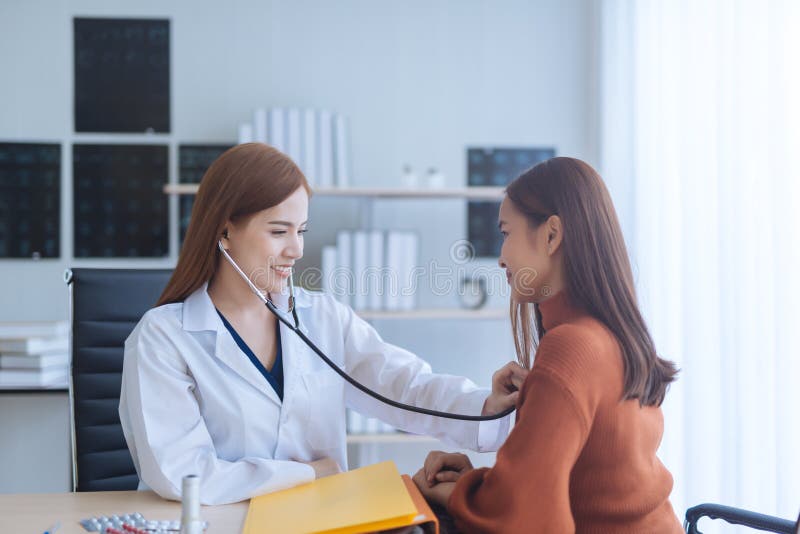 Mulher de exame do doutor asiático da mulher em um hospital imagem de stock Mulher de exame do doutor asiático da mulher em um hospital imagem de stock