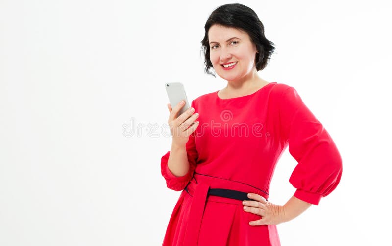 A mulher de meia idade bonita feliz no vestido vermelho usa seu telefone Mulher moreno de encantamento que conversa no Internet fotos de stock royalty free A mulher de meia idade bonita feliz no vestido vermelho usa seu telefone Mulher moreno de encantamento que conversa no Internet fotos de stock royalty free