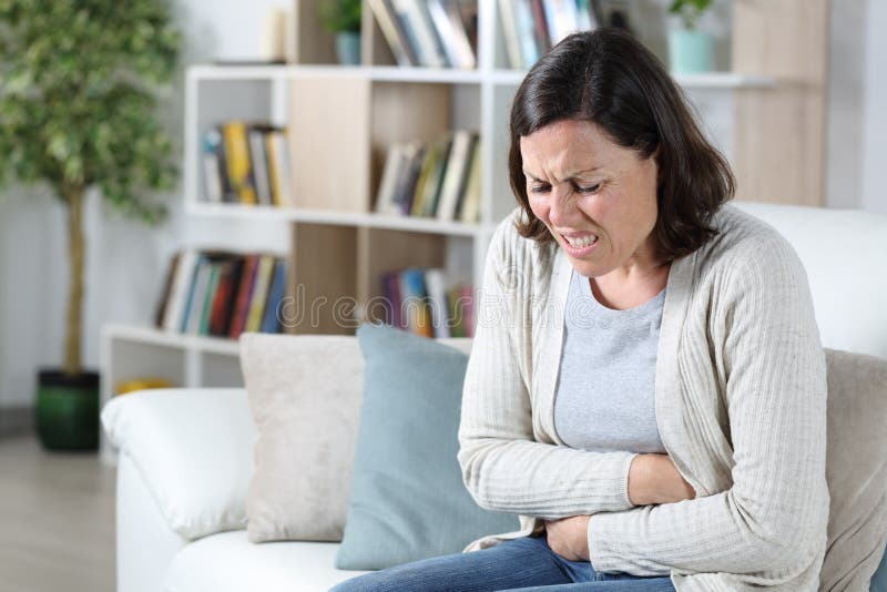 Mulher de meia-idade com dor de estômago em casa