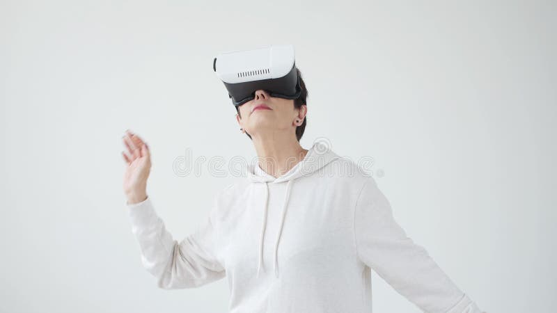 Mulher de meia idade em uma camiseta branca que olha um filme com vidros da realidade virtual O conceito do futurismo e novo vídeos de arquivo Mulher de meia idade em uma camiseta branca que olha um filme com vidros da realidade virtual O conceito do futurismo e novo vídeos de arquivo