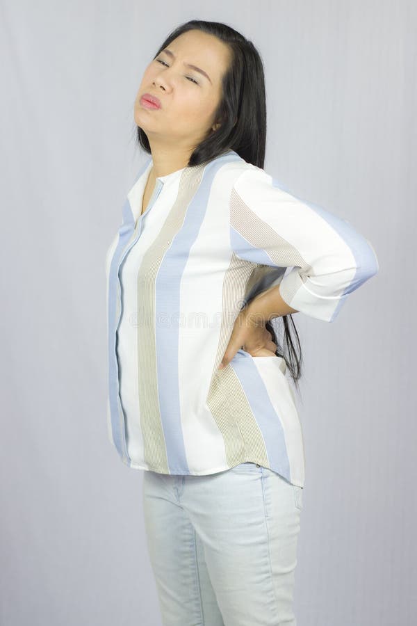Mulher de neg?cio com a dor nas costas, sofrendo da dor nas costas isolada no fundo cinzento foto de stock Mulher de neg?cio com a dor nas costas, sofrendo da dor nas costas isolada no fundo cinzento foto de stock