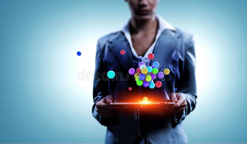 Mulher de neg?cios que guarda um tabalet com um grupo das esferas que levitam acima Meios mistos foto de stock Mulher de neg?cios que guarda um tabalet com um grupo das esferas que levitam acima Meios mistos foto de stock