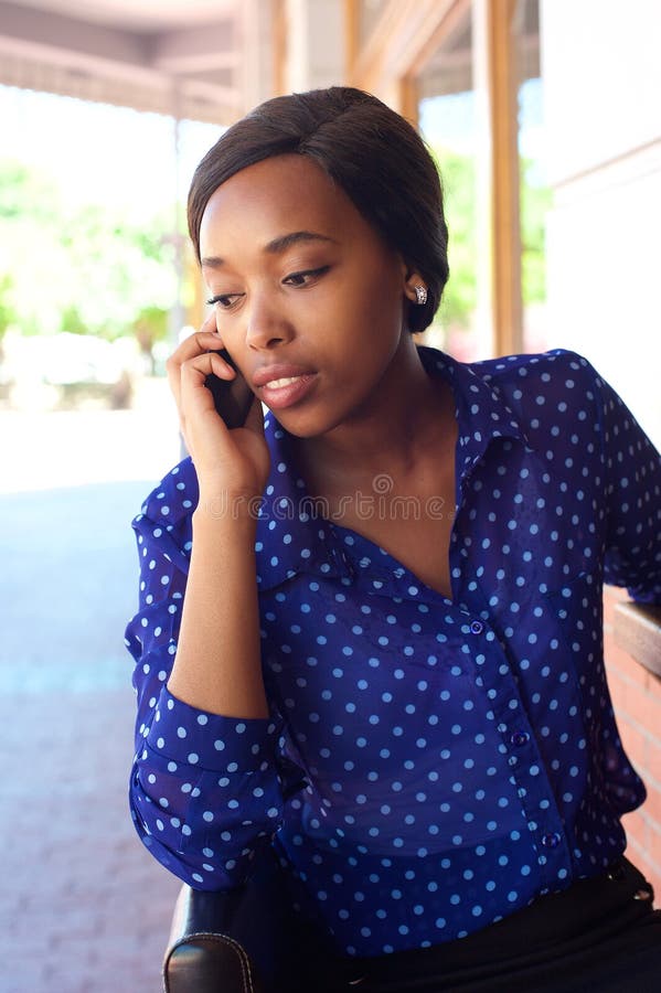 Mulher de negócio afro-americano que escuta o telefone celular imagem de stock Mulher de negócio afro-americano que escuta o telefone celular imagem de stock