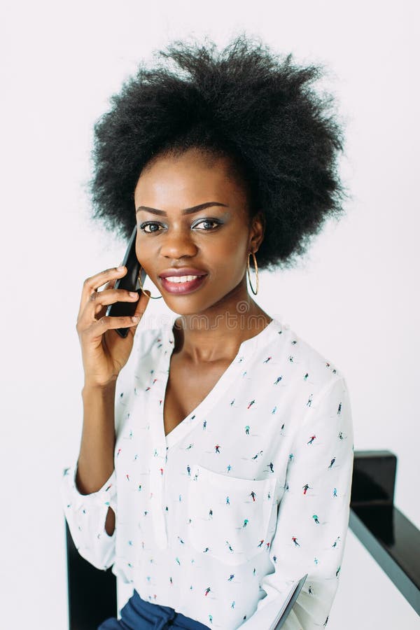 Mulher de negócio afro-americano de sorriso nova que usa o telefone, isolado no branco fotos de stock Mulher de negócio afro-americano de sorriso nova que usa o telefone, isolado no branco fotos de stock