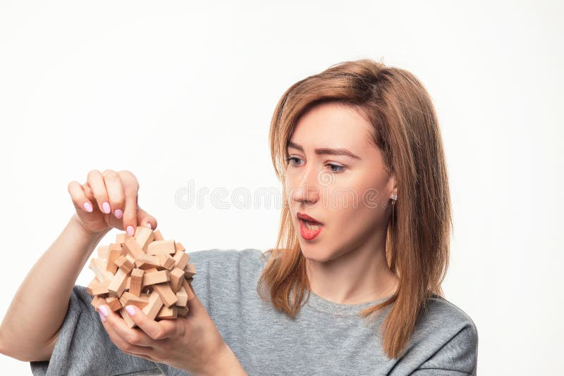 Mulher de negócio atrativa das pessoas de 24 anos que olha confundida com o enigma de madeira fotos de stock royalty free Mulher de negócio atrativa das pessoas de 24 anos que olha confundida com o enigma de madeira fotos de stock royalty free
