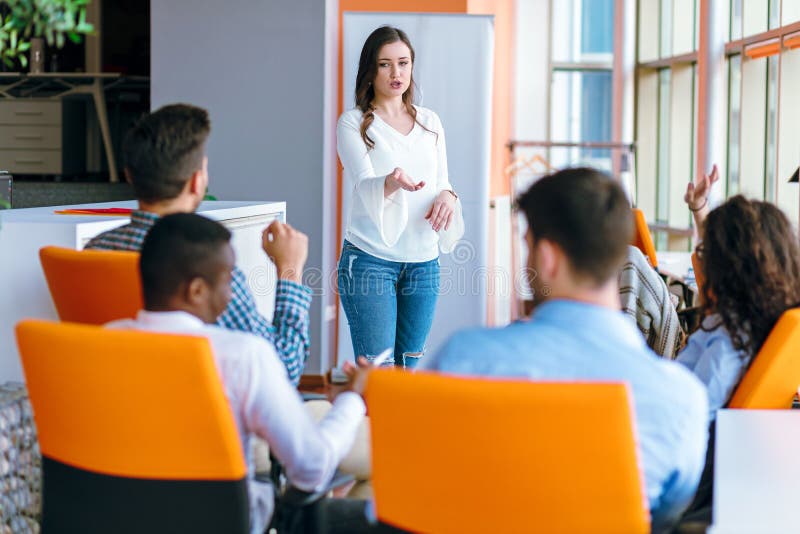 Mulher de negócio consideravelmente nova que dá uma apresentação na conferência ou que encontra o ajuste fotos de stock royalty free Mulher de negócio consideravelmente nova que dá uma apresentação na conferência ou que encontra o ajuste fotos de stock royalty free