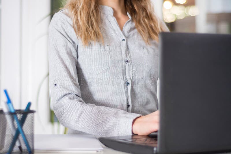 Mulher de negócio elegante que trabalha na mesa no escritório no portátil foto de stock Mulher de negócio elegante que trabalha na mesa no escritório no portátil foto de stock