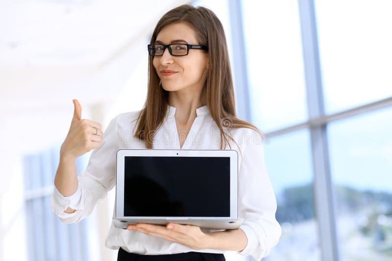 Mulher de negócio moderna que datilografa no laptop ao estar no escritório antes de encontrar ou de apresentação imagem de stock Mulher de negócio moderna que datilografa no laptop ao estar no escritório antes de encontrar ou de apresentação imagem de stock