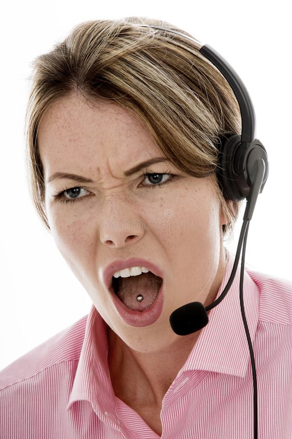 Mulher de negócio nova atrativa irritada que usa uns auriculares do telefone imagem de stock Mulher de negócio nova atrativa irritada que usa uns auriculares do telefone imagem de stock