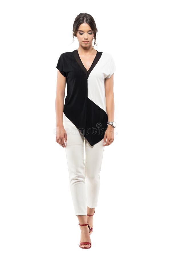 Mulher de negócio nova elegante no terno preto e branco que anda e que olha para baixo imagens de stock Mulher de negócio nova elegante no terno preto e branco que anda e que olha para baixo imagens de stock