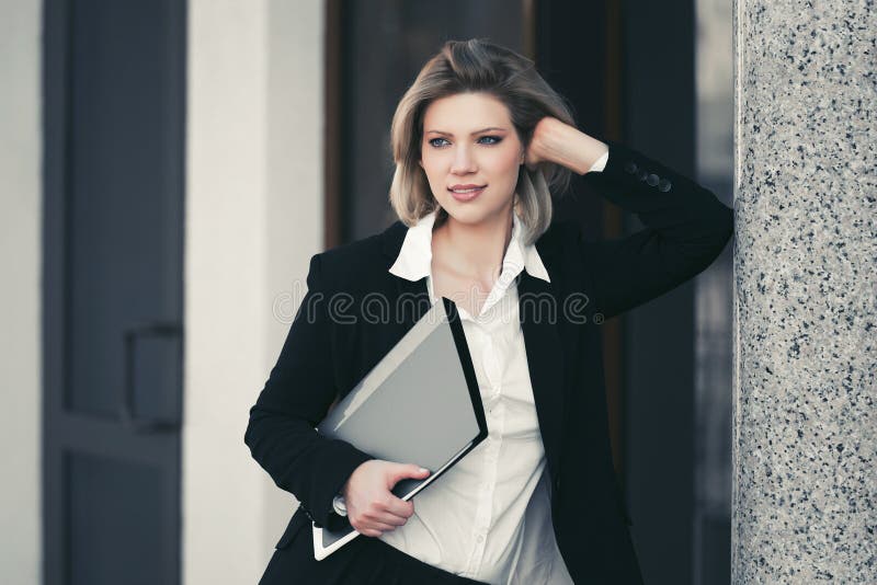 Mulher de negócio nova feliz com a pasta de arquivos no prédio de escritórios fotos de stock Mulher de negócio nova feliz com a pasta de arquivos no prédio de escritórios fotos de stock