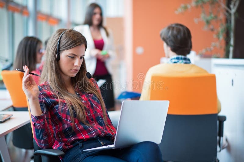 Mulher de negócio nova feliz com seu pessoal, grupo dos povos no fundo no escritório brilhante moderno dentro imagens de stock Mulher de negócio nova feliz com seu pessoal, grupo dos povos no fundo no escritório brilhante moderno dentro imagens de stock