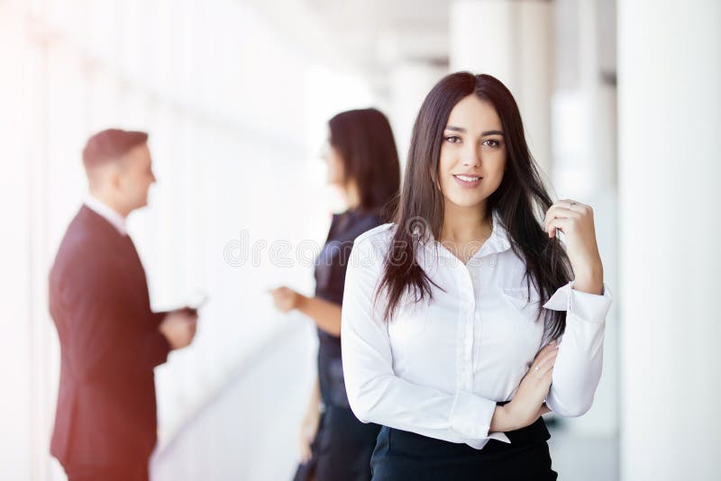 Mulher de negócio que conduz uma equipe incorporada na frente dos colegas de fala fotografia de stock royalty free Mulher de negócio que conduz uma equipe incorporada na frente dos colegas de fala fotografia de stock royalty free