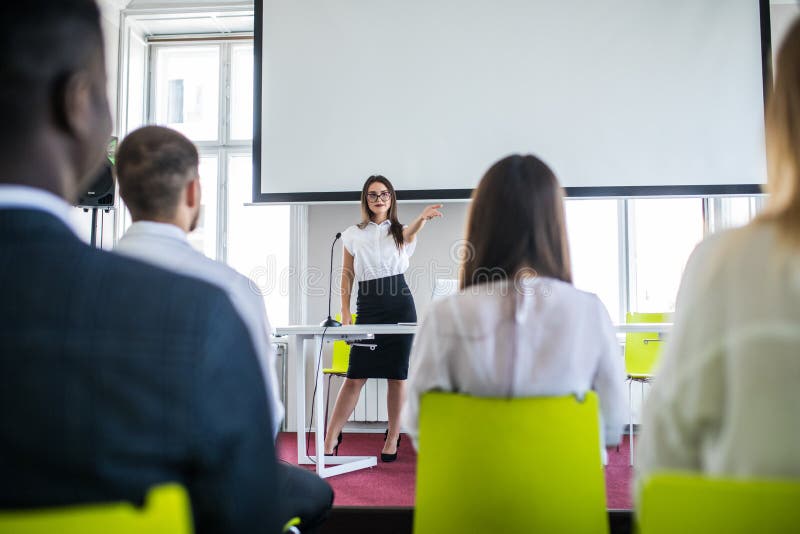 Mulher de negócio que fala na conferência Audiência no salão de leitura Multi empresa étnica imagem de stock Mulher de negócio que fala na conferência Audiência no salão de leitura Multi empresa étnica imagem de stock