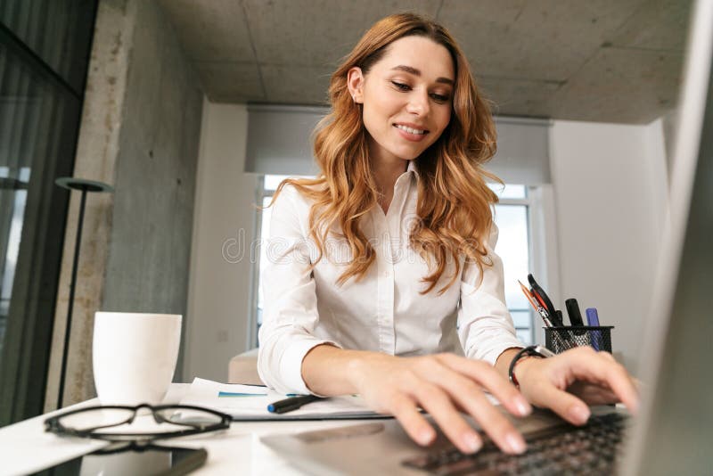 Mulher de negócio vestida na camisa formal da roupa que usa dentro o laptop imagem de stock Mulher de negócio vestida na camisa formal da roupa que usa dentro o laptop imagem de stock