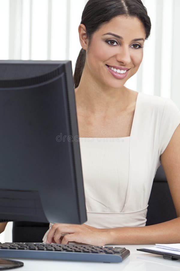 Mulher de negócios & computador latino-americanos da mulher no escritório imagens de stock Mulher de negócios & computador latino-americanos da mulher no escritório imagens de stock