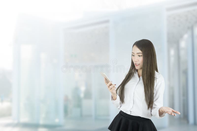 Mulher de negócios asiática confusa que usa o smartphone foto de stock Mulher de negócios asiática confusa que usa o smartphone foto de stock
