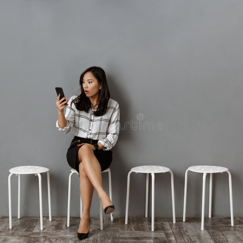 mulher de negócios asiática emocional com espera do smartphone imagem de stock mulher de negócios asiática emocional com espera do smartphone imagem de stock