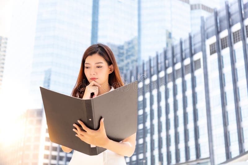 A mulher de negócios bonita encantador olha o documento e o ab de pensamento imagens de stock A mulher de negócios bonita encantador olha o documento e o ab de pensamento imagens de stock