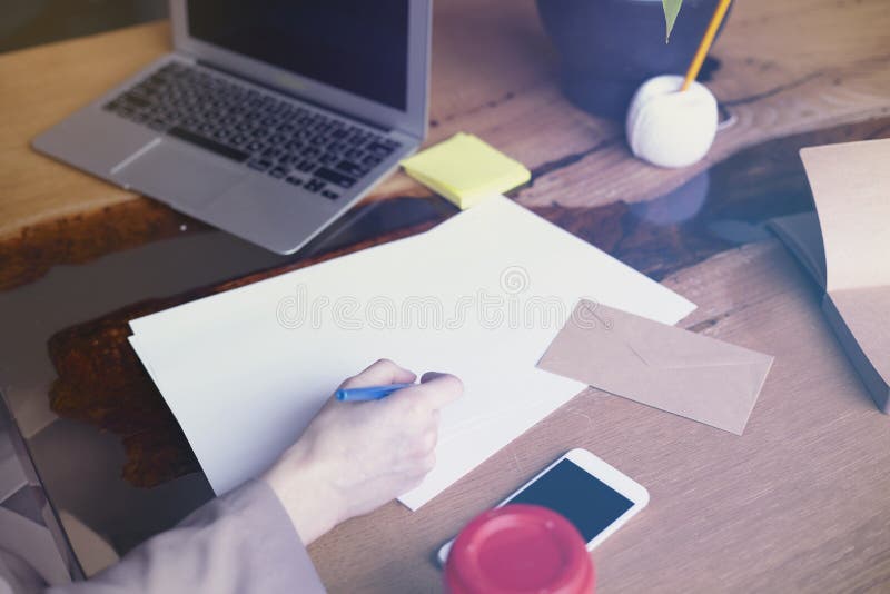 Mulher de negócios com a folha de papel dos originais no escritório moderno do sótão, trabalhando no laptop Funcionamento da equi imagem de stock royalty free Mulher de negócios com a folha de papel dos originais no escritório moderno do sótão, trabalhando no laptop Funcionamento da equi imagem de stock royalty free