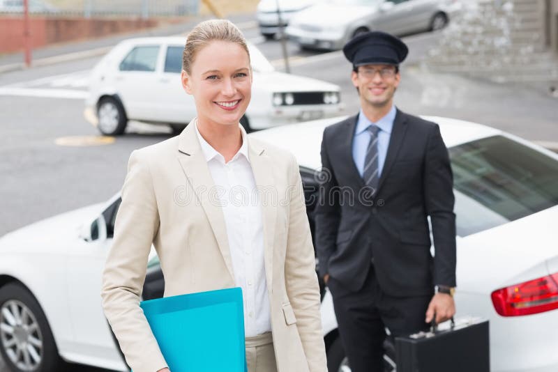 Mulher de negócios e seu motorista que sorriem na câmera imagens de stock royalty free Mulher de negócios e seu motorista que sorriem na câmera imagens de stock royalty free