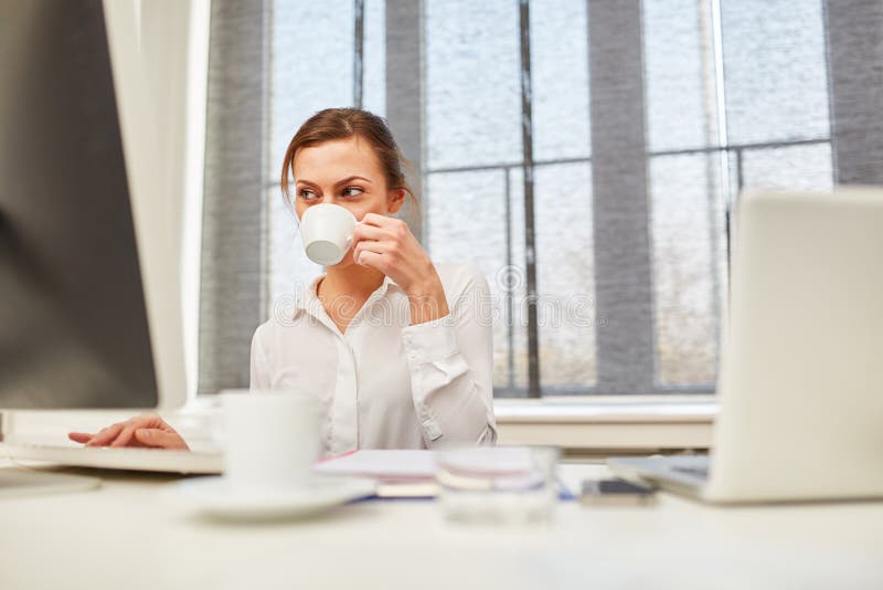 Mulher de negócios em seu café bebendo da mesa imagem de stock Mulher de negócios em seu café bebendo da mesa imagem de stock
