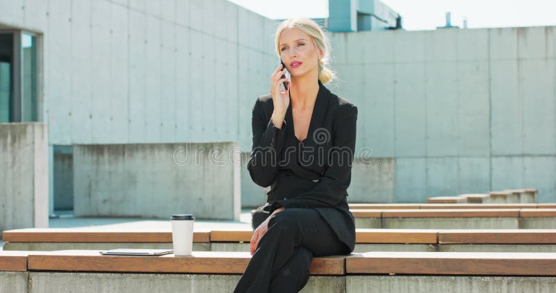 Mulher de negócios falando no celular jovem mulher bonita moderna e elegante no escuro
