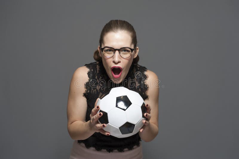 A mulher de neg?cios positiva nova nos vidros exulta no sucesso que guarda ? disposi??o o bal fotografia de stock A mulher de neg?cios positiva nova nos vidros exulta no sucesso que guarda ? disposi??o o bal fotografia de stock