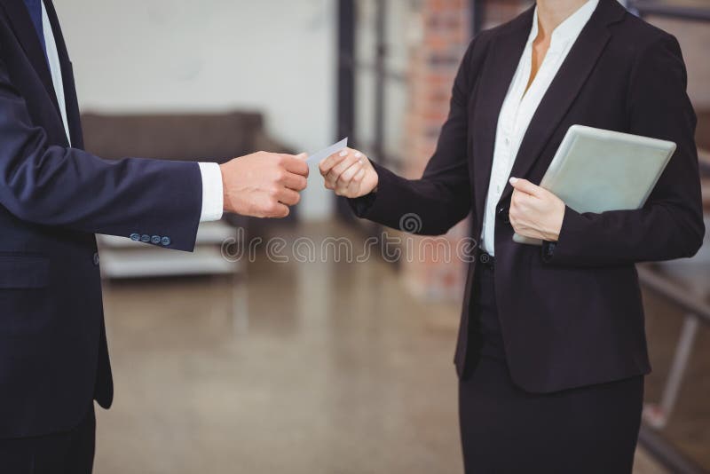 Mulher de negócios que dá o cartão ao cliente no escritório imagem de stock royalty free Mulher de negócios que dá o cartão ao cliente no escritório imagem de stock royalty free