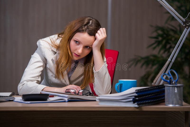 A mulher de negócios que fica no escritório para o muito tempo imagens de stock royalty free A mulher de negócios que fica no escritório para o muito tempo imagens de stock royalty free
