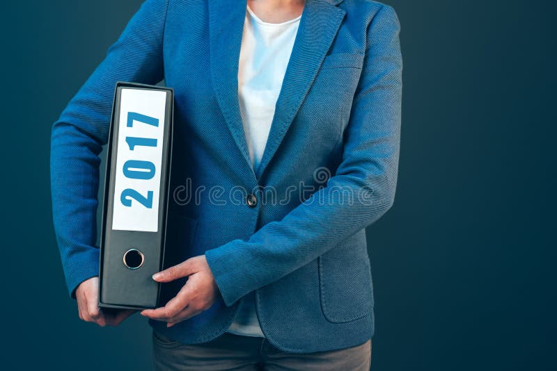 Mulher de negócios que guarda a pasta de 2017 originais com arquivos arquivados imagem de stock royalty free Mulher de negócios que guarda a pasta de 2017 originais com arquivos arquivados imagem de stock royalty free
