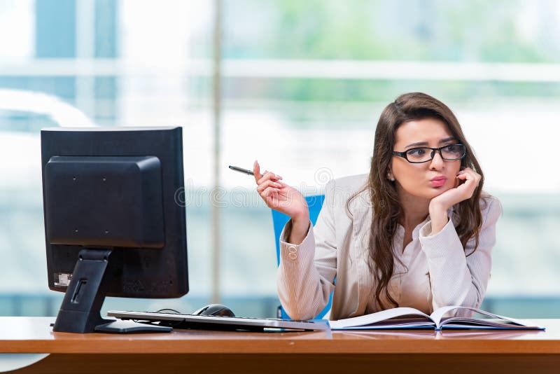 A mulher de negócios que senta-se na mesa de escritório fotos de stock