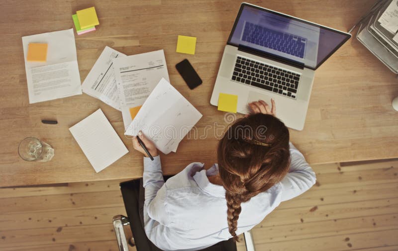 Mulher de negócios que trabalha em sua mesa de escritório com originais e portátil