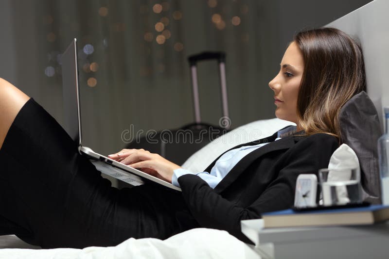 Mulher de negócios que trabalha horas atrasadas durante a viagem de negócios imagem de stock royalty free Mulher de negócios que trabalha horas atrasadas durante a viagem de negócios imagem de stock royalty free