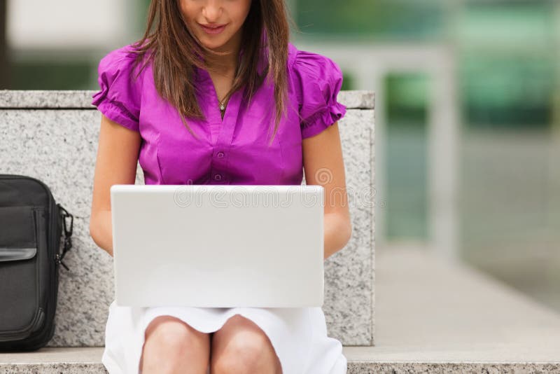 Mulher de negócios que usa o portátil ao ar livre imagem de stock Mulher de negócios que usa o portátil ao ar livre imagem de stock