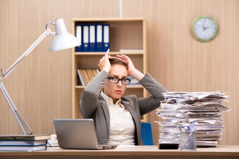 A mulher de negócios sob o esforço de demasiado trabalho no escritório imagem de stock royalty free A mulher de negócios sob o esforço de demasiado trabalho no escritório imagem de stock royalty free