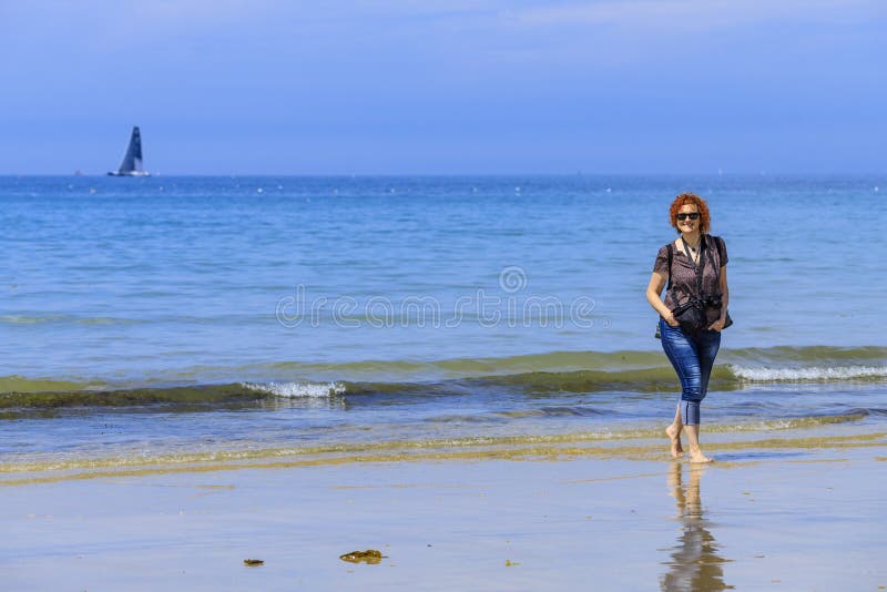 Mulher de Redhed no litoral fotografia de stock Mulher de Redhed no litoral fotografia de stock