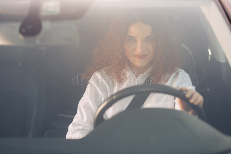 Mulher de sorriso bonita que conduz o carro, menina atrativa que senta-se no autom?vel, fora retrato do ver?o imagem de stock royalty free Mulher de sorriso bonita que conduz o carro, menina atrativa que senta-se no autom?vel, fora retrato do ver?o imagem de stock royalty free