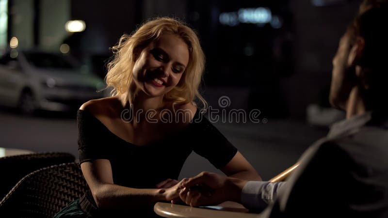 Mulher de sorriso bonita que senta-se com o amado no terra?o do caf?, data perfeita, amor imagem de stock Mulher de sorriso bonita que senta-se com o amado no terra?o do caf?, data perfeita, amor imagem de stock