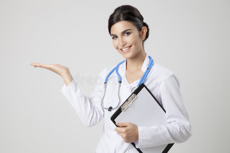 Mulher de sorriso do médico com estetoscópio Presente algo fotografia de stock