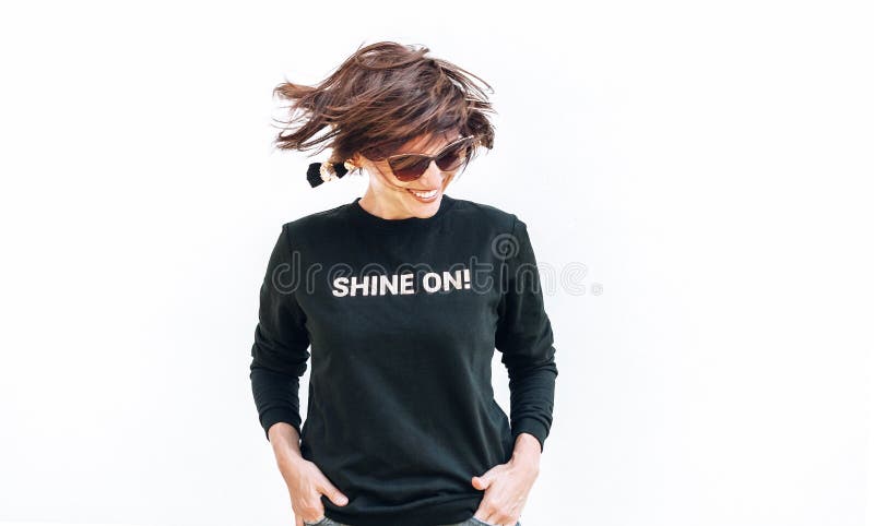 Free feeling happy smiling woman posing in black sweatshirt with positive print Shine On. Free feeling happy smiling woman posing in black sweatshirt with positive print Shine On