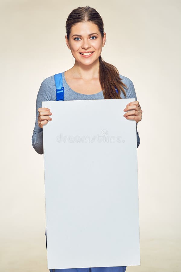 Mulher de sorriso na combinação do construtor que guarda a placa de propaganda grande imagem de stock royalty free